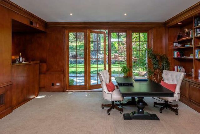 a view of a workspace with furniture and a window