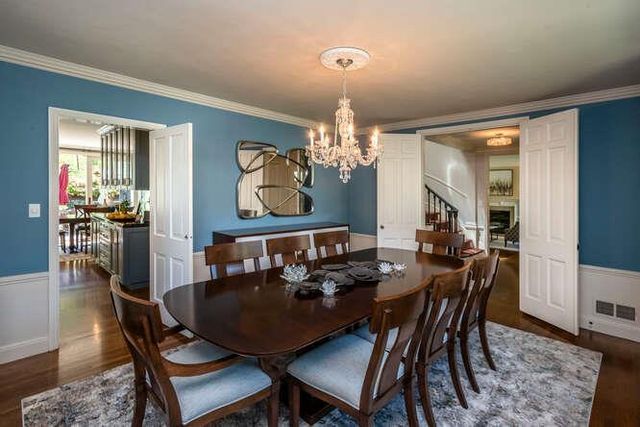a view of a dining room with furniture a chandelier and wooden floor