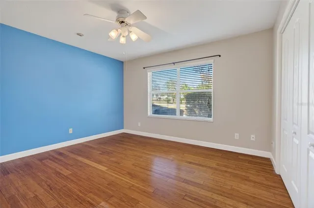 a view of an empty room with window and wooden floor