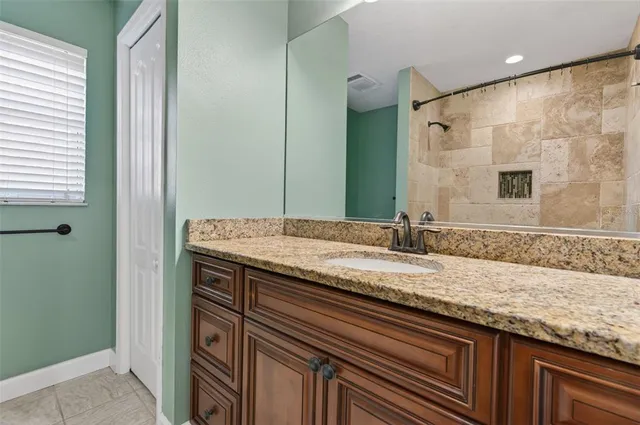 a bathroom with a granite countertop sink and a mirror