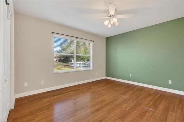 an empty room with windows and fan