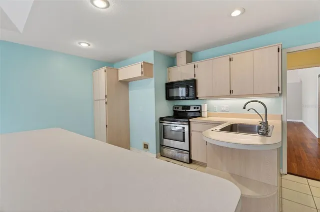 a kitchen with a sink a stove a microwave and cabinets
