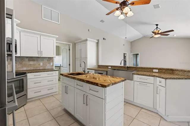 a kitchen with a sink dishwasher a stove a dining table and chairs with wooden floor