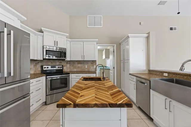 a kitchen with stainless steel appliances granite countertop a sink dishwasher stove top oven and refrigerator