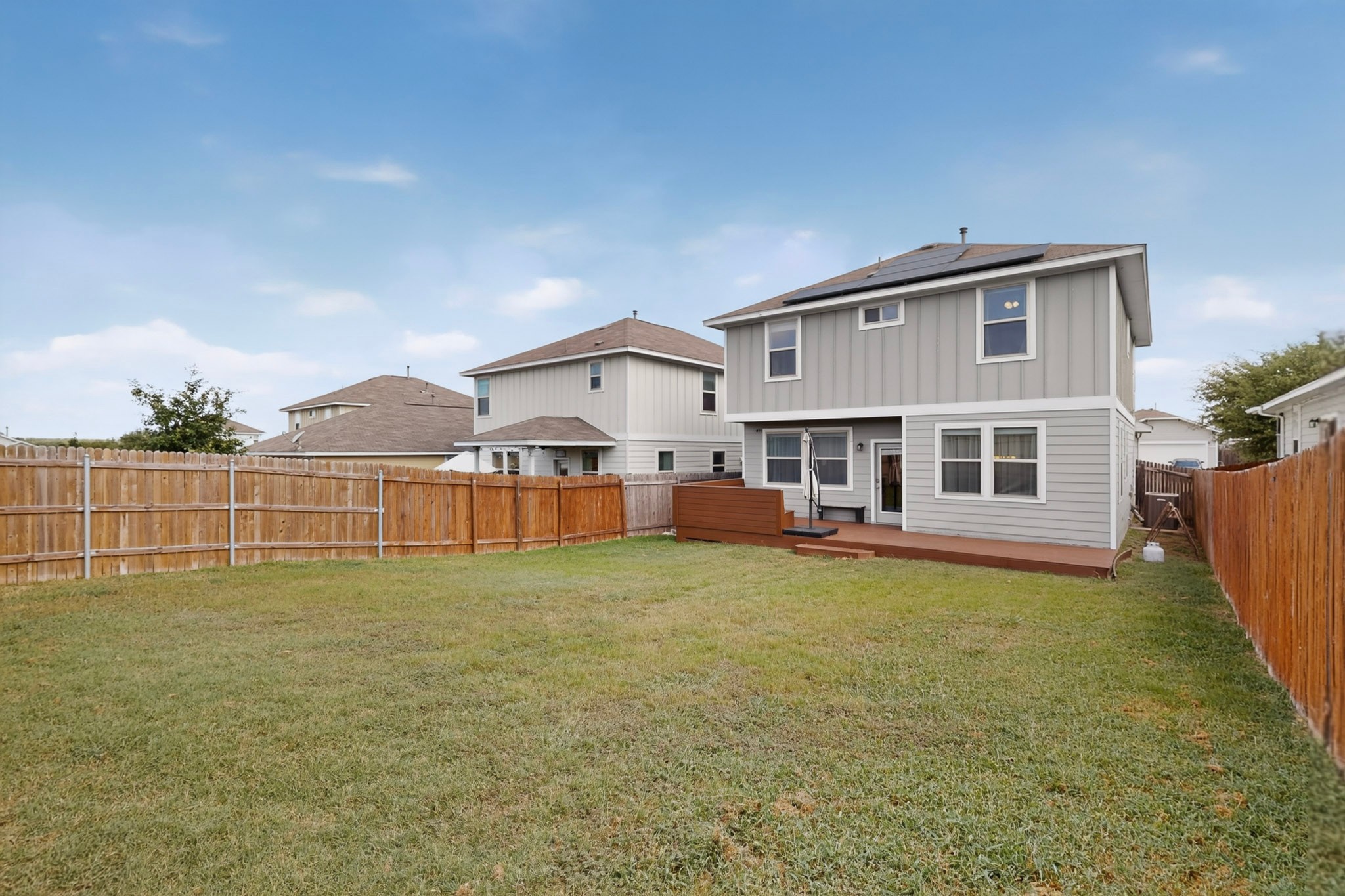 132 Wapiti Road Buda, TX 78610 - Photo 26 of 31 A spacious backyard awaits, complete with a private fence and an inviting wooden deck.