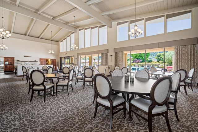 a dining room with furniture a chandelier and window