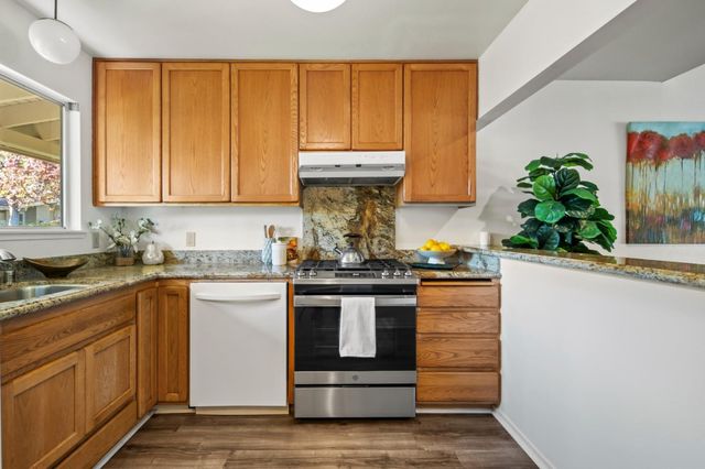 a kitchen with stainless steel appliances granite countertop a stove and a sink