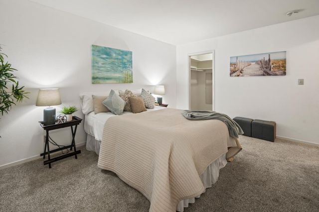 a bedroom with a bed chair and painting on the wall