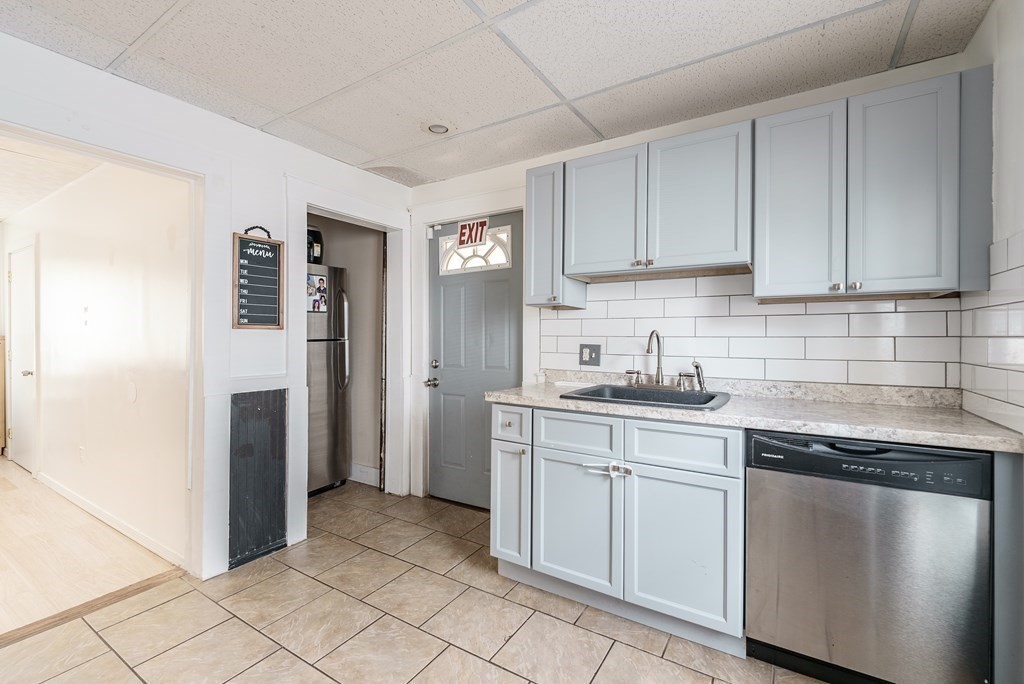 26 Beech Street Springfield, MA 01105 - Photo 5 of 24 a kitchen with white cabinets and refrigerator