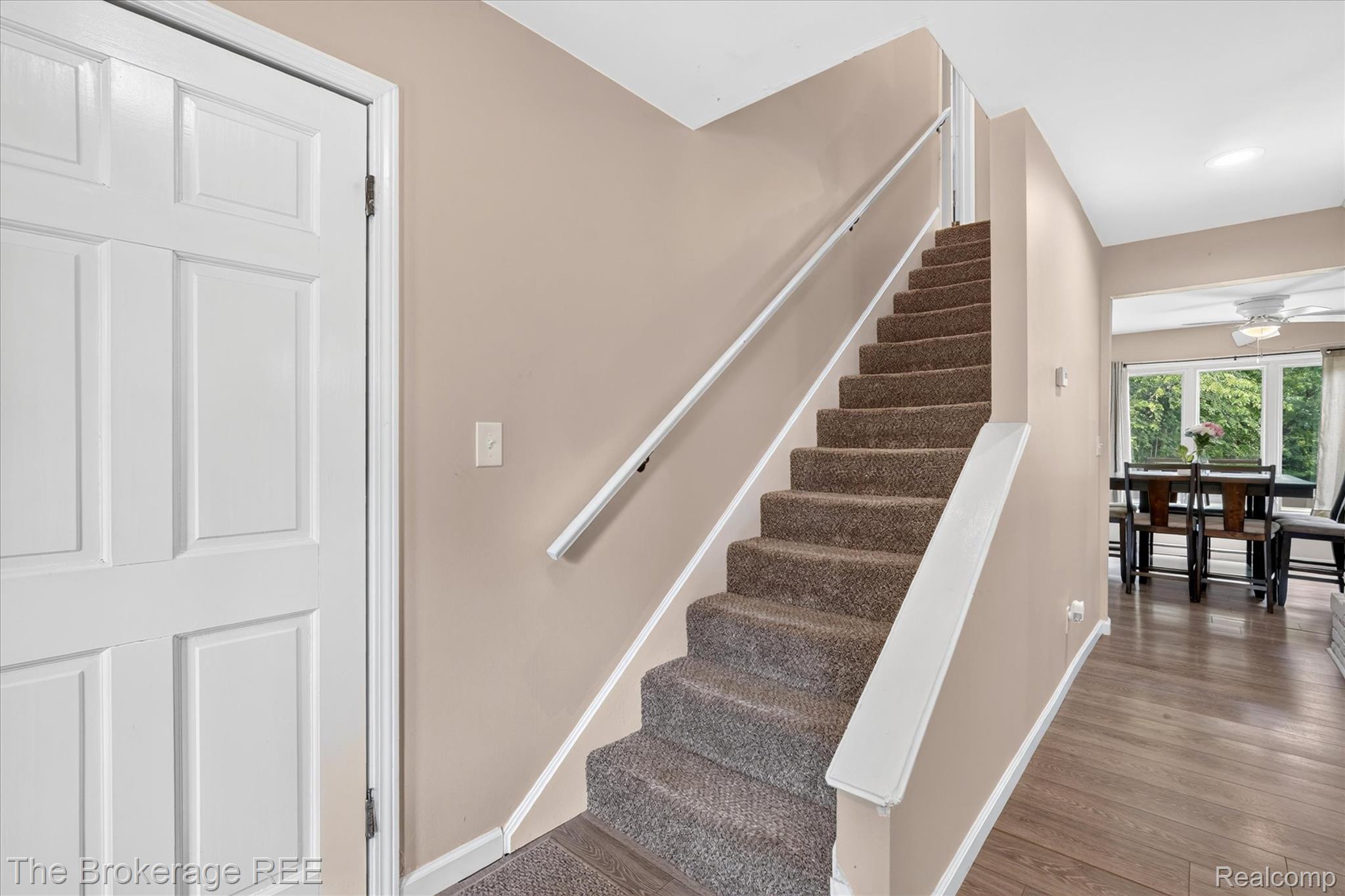 13269 North Genesee Road Clio, MI 48420 - Photo 10 of 67 Carpeted staircase with white handrails and trim, complemented by wood-finish flooring