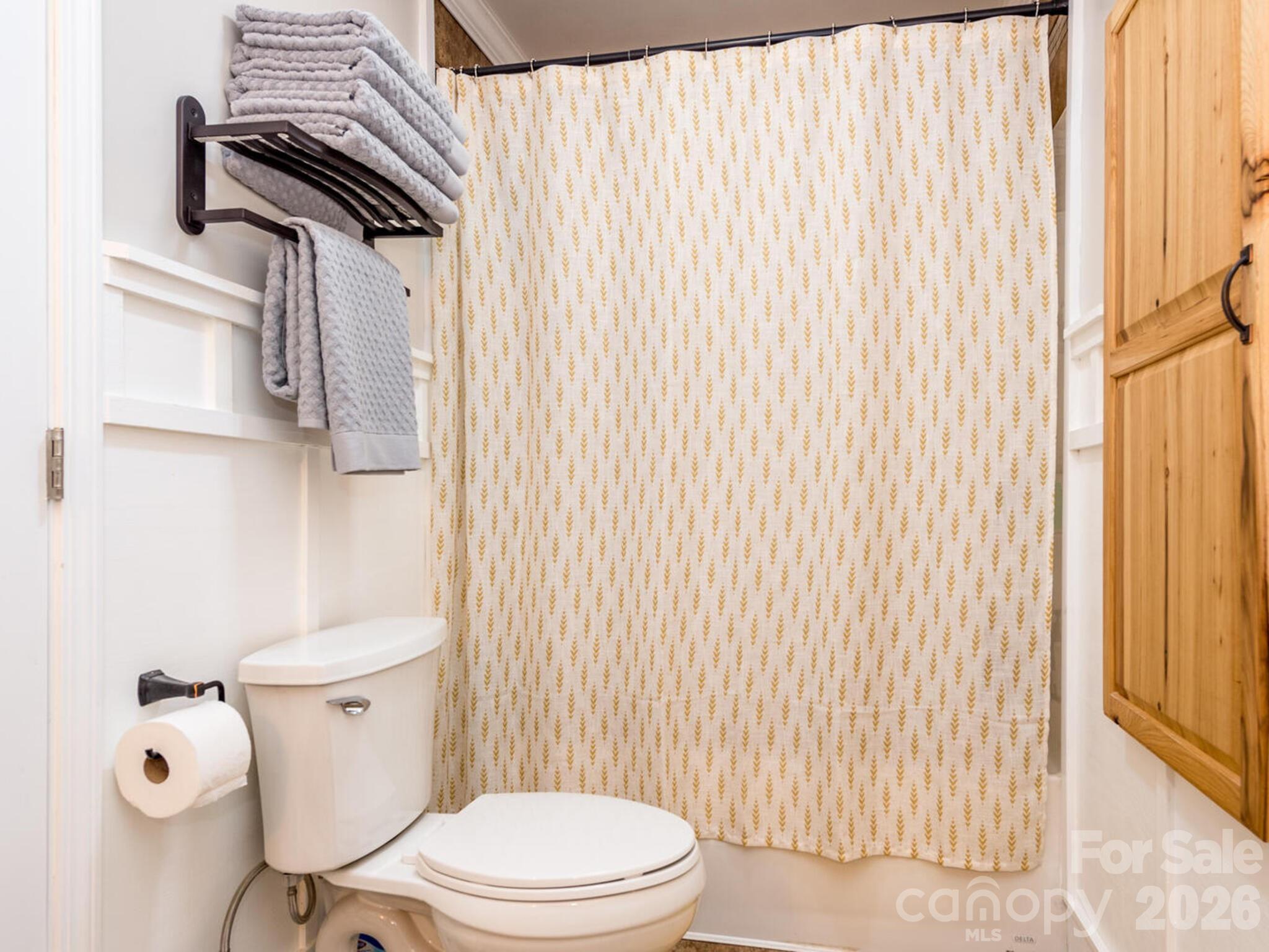 29 White Oak Road Arden, NC 28704 - Photo 25 of 42 a white toilet sitting next to a shower curtain
