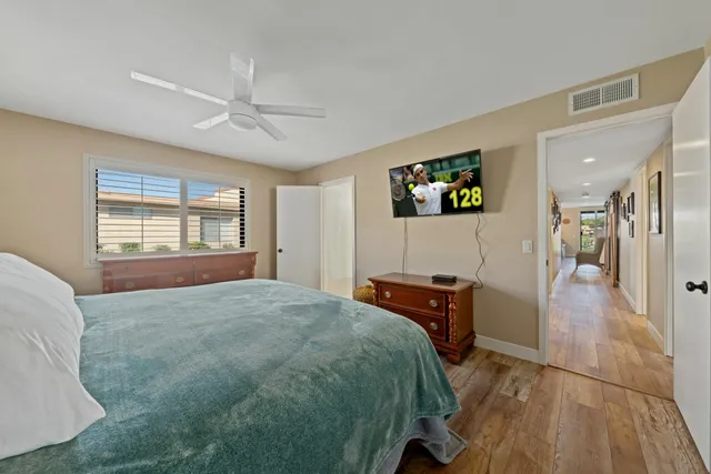 a bedroom with a bed and wooden floor