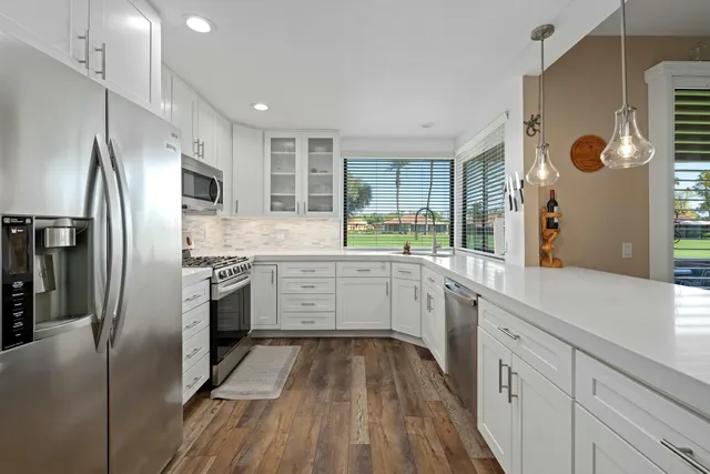 a kitchen with a sink stainless steel appliances and cabinets