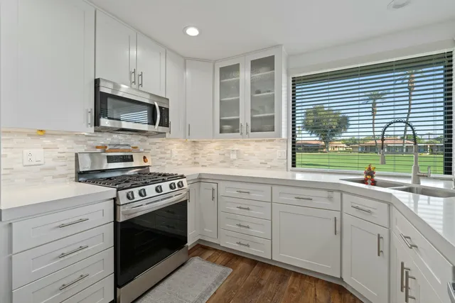 a kitchen with granite countertop cabinets stainless steel appliances and a window