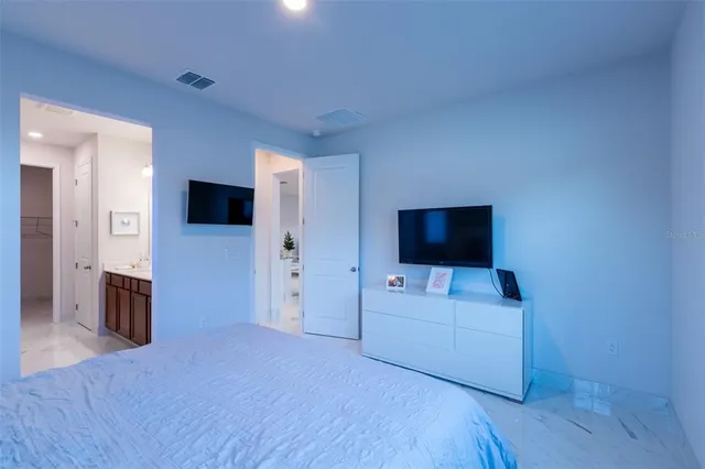 a living room with a flat screen tv on dresser and a wooden floor
