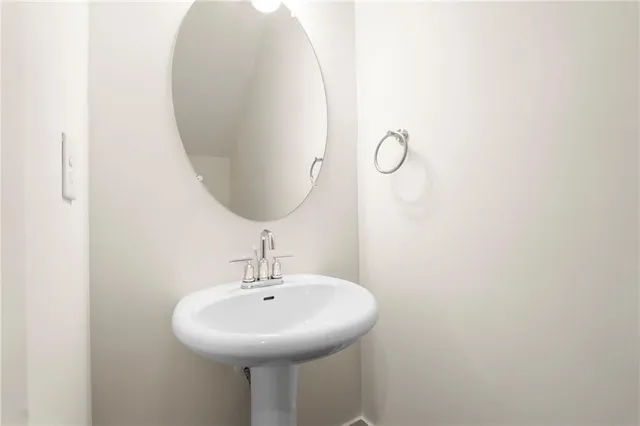 a view of a hallway with wooden floor and a bathroom