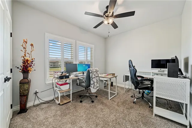 a view of a workspace with furniture and a window