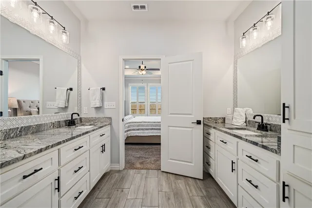 a spacious bathroom with a granite countertop sink mirror and