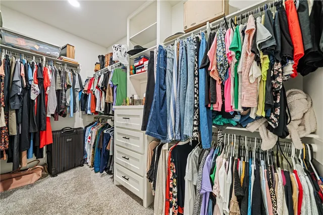 a view of walk in closet with clothes