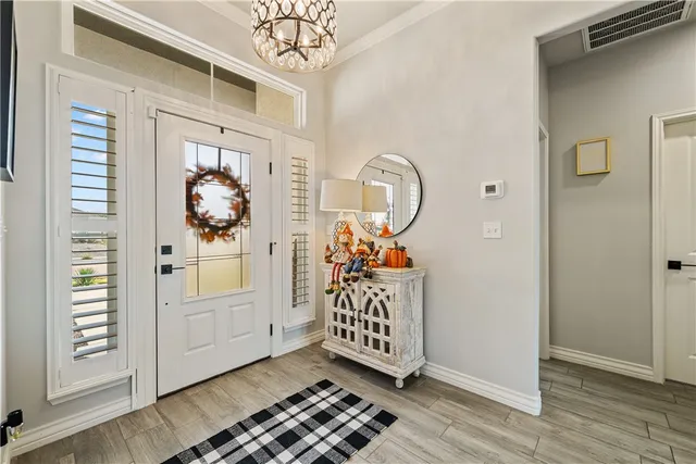 a view of a livingroom with wooden floor and a chandelier