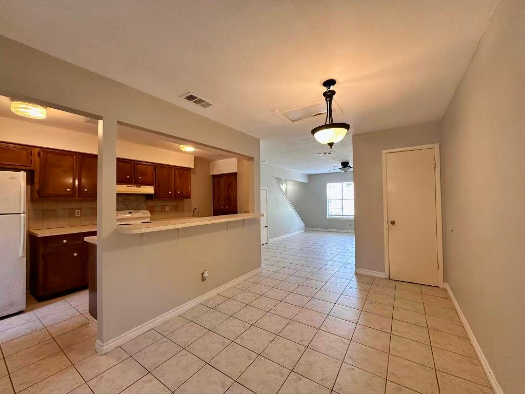 202 2nd Street North, Unit D Pflugerville, TX 78660 - Photo 4 of 15 a view of a kitchen with a sink and a refrigerator