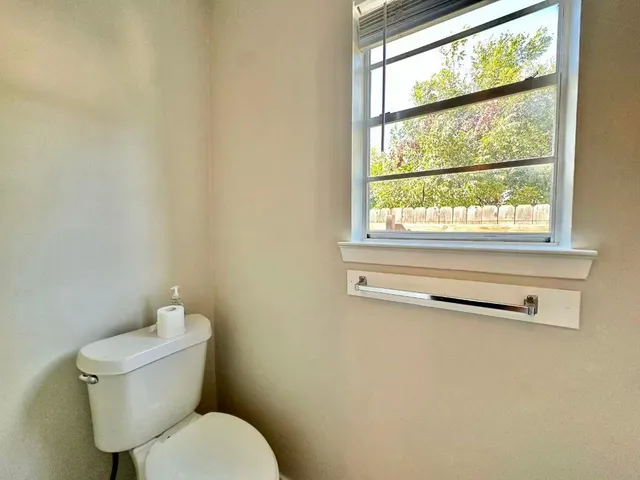 a white toilet sitting next to a window