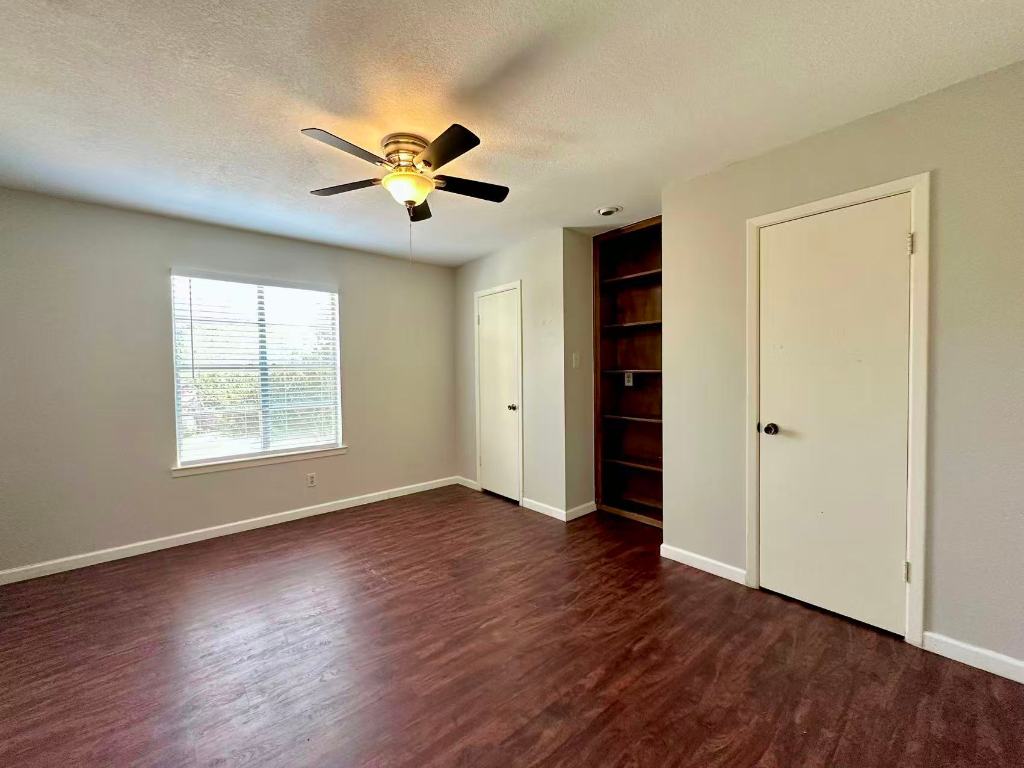 202 2nd Street North, Unit D Pflugerville, TX 78660 - Photo 8 of 15 a view of an empty room with a window and wooden floor