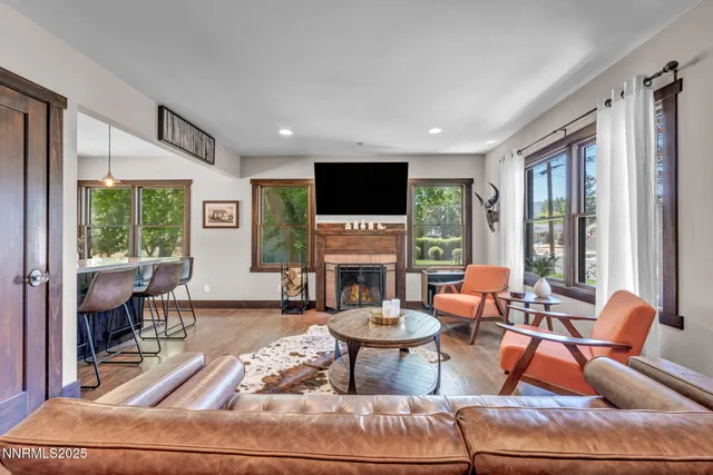 a living room with furniture a fireplace and a floor to ceiling window