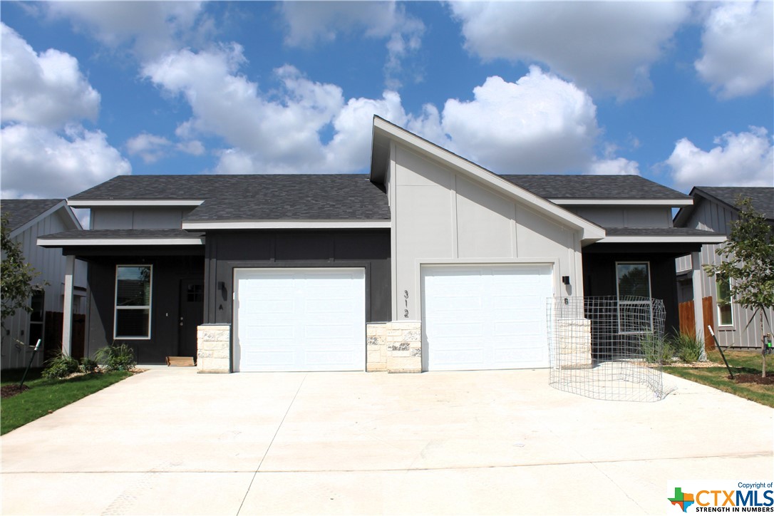 a front view of a house with a garden and pathway