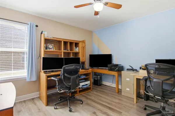a view of a workspace with furniture and a window