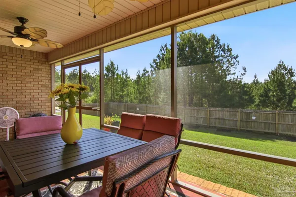 a view of a porch with furniture and a yard