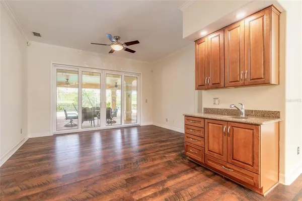 an empty room with chandelier fan and windows
