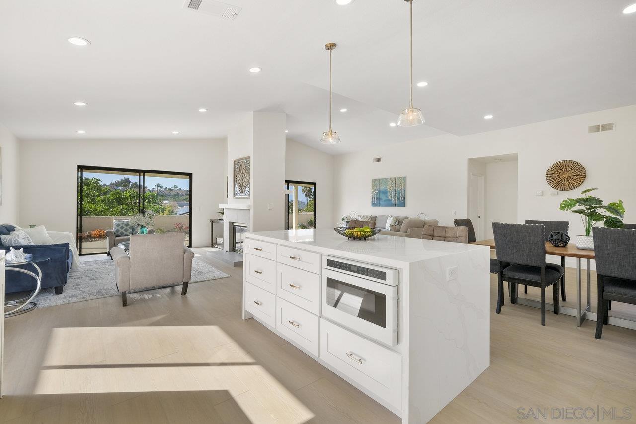 a large white kitchen with kitchen island a couches table and chairs