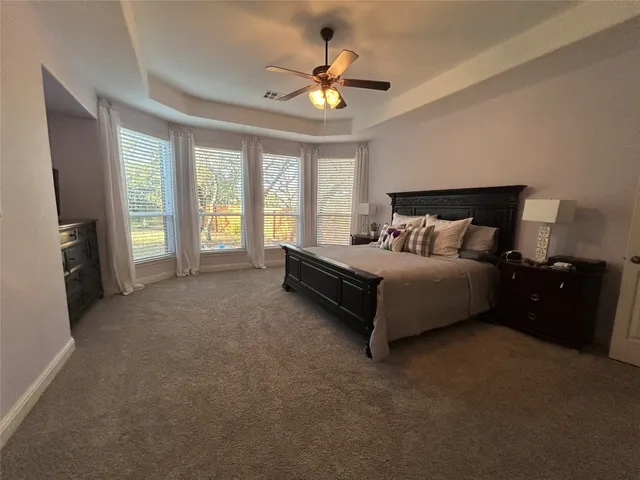 a spacious bedroom with a bed and a ceiling fan