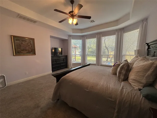 a bedroom with a large bed chandelier and a window