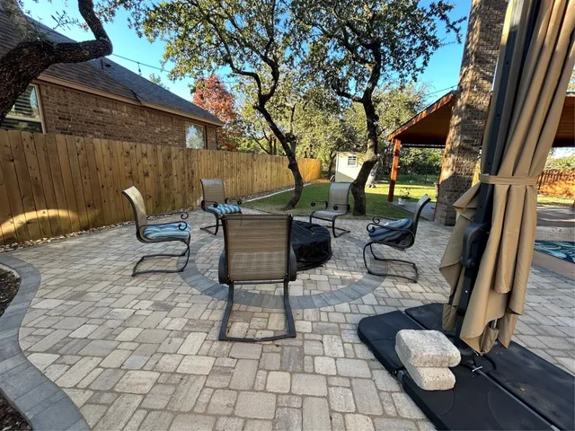 a backyard of a house with barbeque oven table and chairs