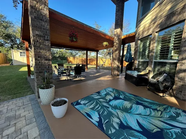 a view of a patio with table and chairs potted plants and a palm tree