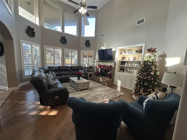 a living room with furniture a chandelier and a flat screen tv