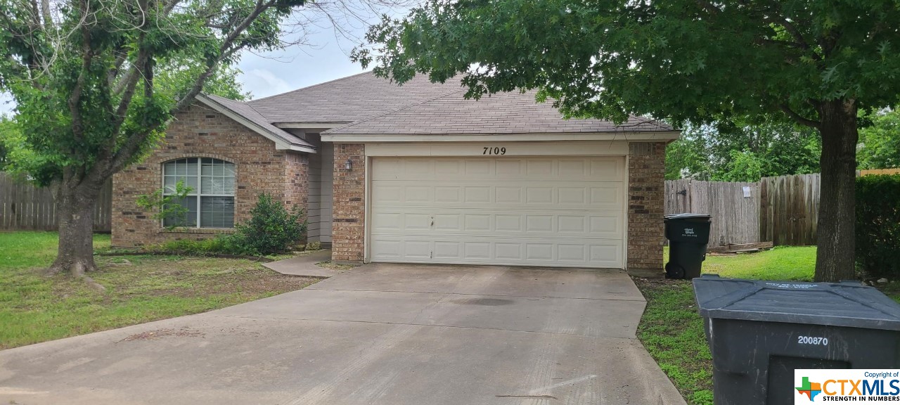 a view of a house with a garage and yard