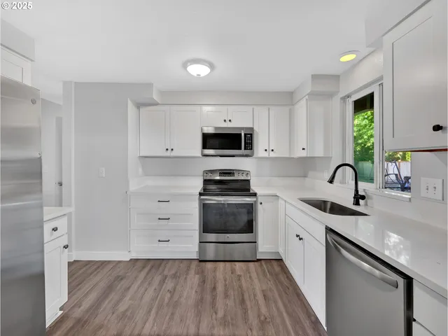 a kitchen with stainless steel appliances a stove sink and cabinets