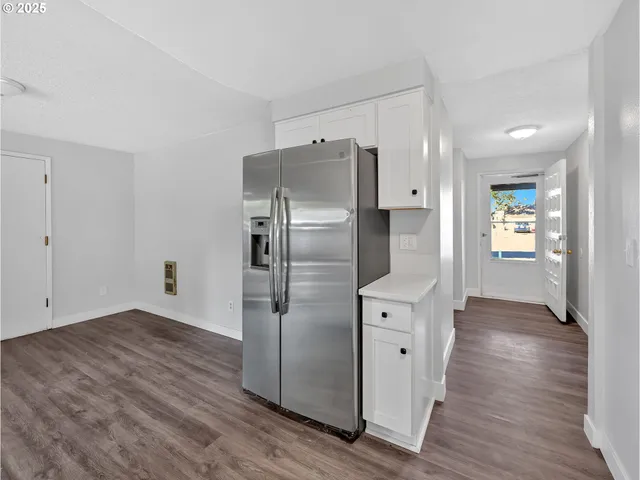 a kitchen with stainless steel appliances a refrigerator and wooden floor