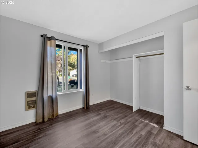 an empty room with wooden floor and a window