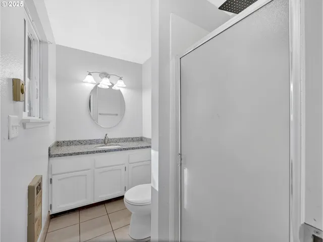 a bathroom with a granite countertop toilet a sink and a mirror