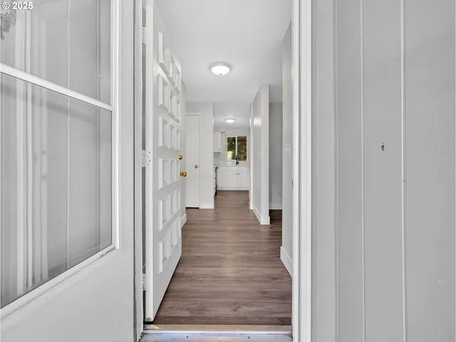 a view of a hallway with wooden floor and closet