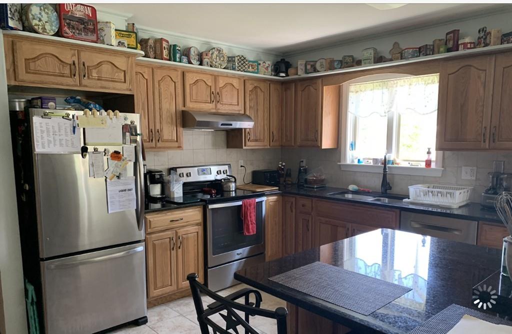 1225 Reed Road Dartmouth, MA 02747 - Photo 6 of 21 a kitchen with stainless steel appliances granite countertop a refrigerator a sink dishwasher a stove a dining table and chairs with wooden floor