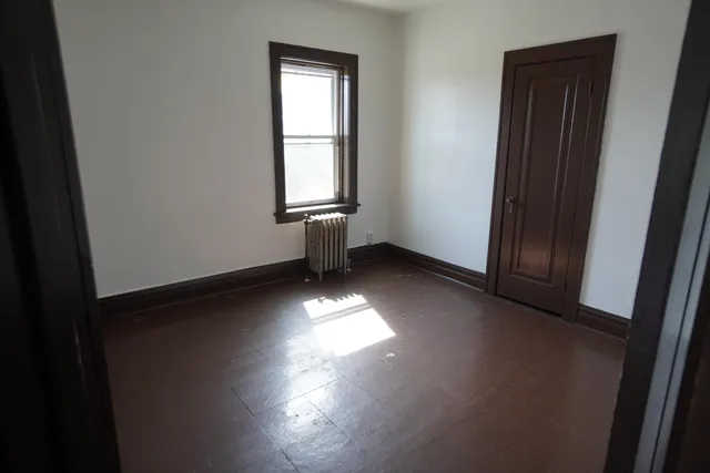 an empty room with windows and closet