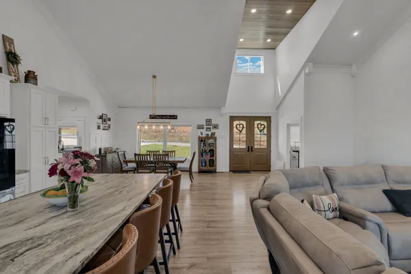 a large kitchen with kitchen island a stove a table and chairs in it