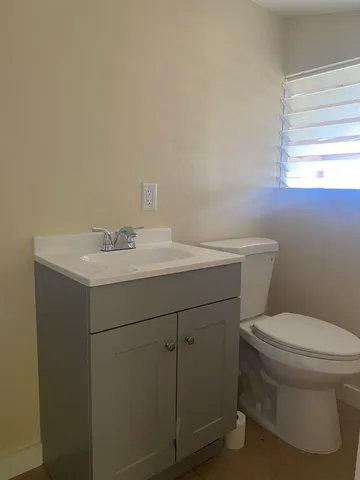 a bathroom with a sink toilet and window