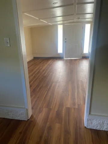 a view of a room with wooden floor and a window