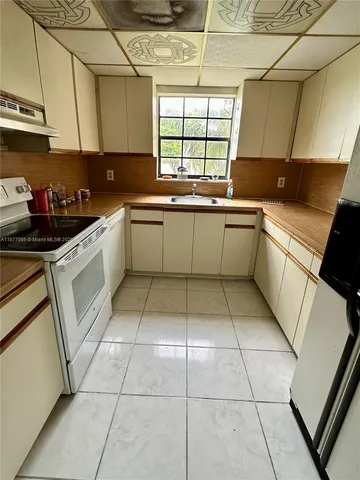 a kitchen with a sink a stove a microwave and cabinets